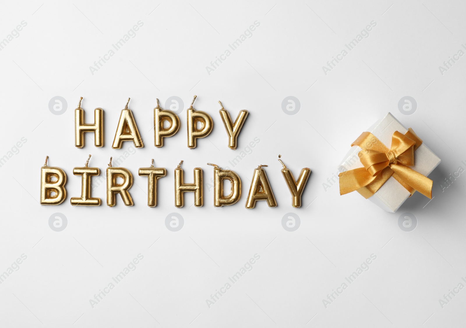 Photo of Flat lay composition with birthday candles and gift box on light background