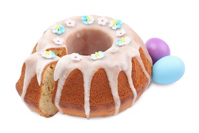 Photo of Festively decorated Easter cake and painted eggs on white background
