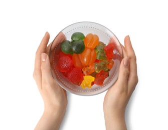 Photo of Woman holding bowl with delicious gummy candies on white background, top view