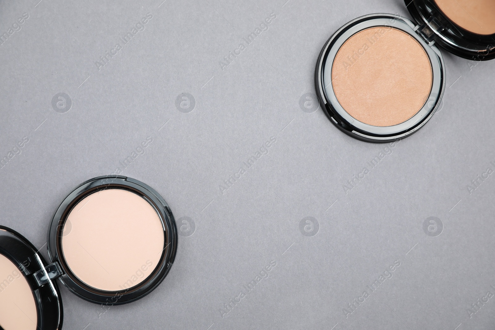 Photo of Open face powders on light grey background, flat lay. Space for text