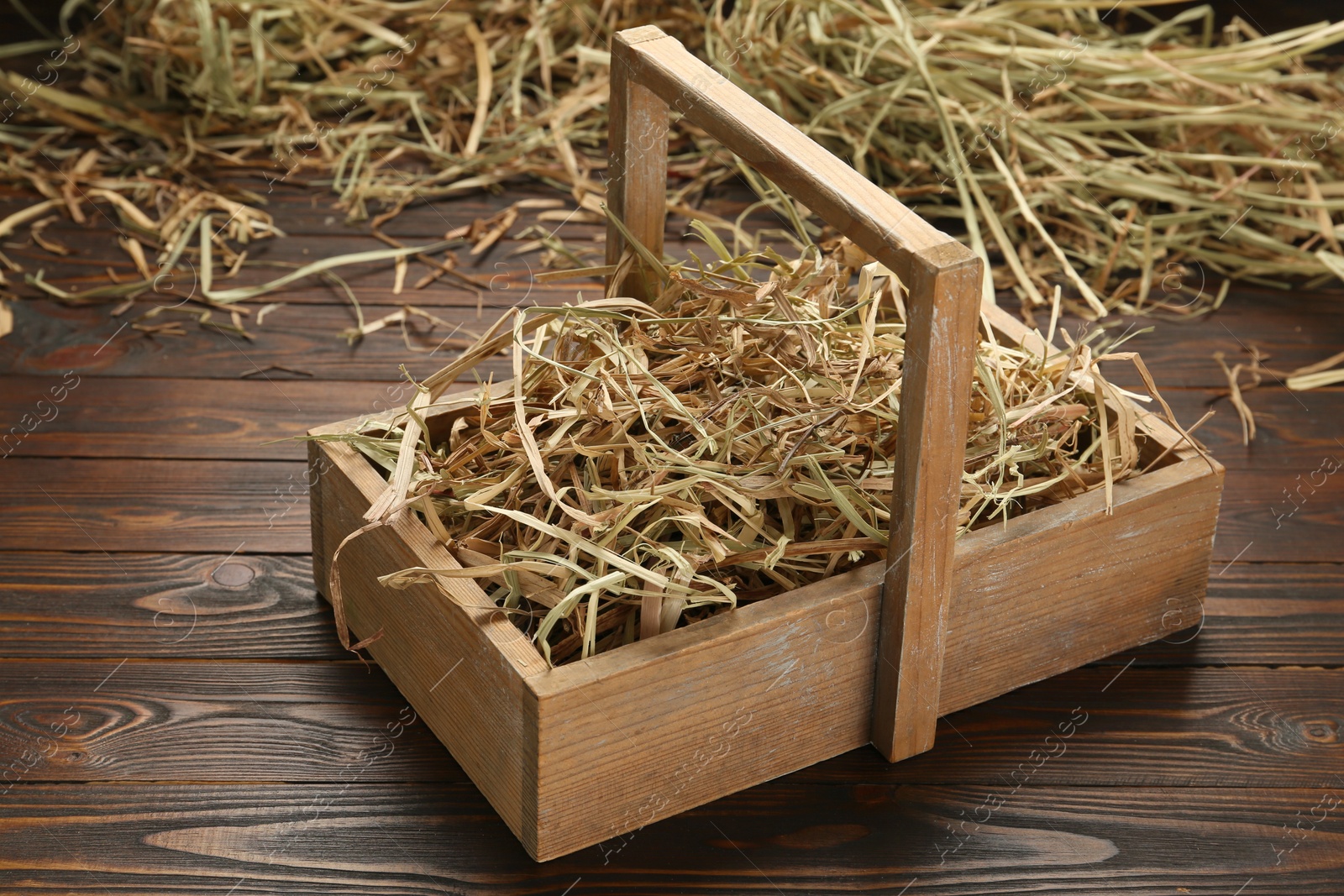 Photo of Dried hay in crate on wooden table