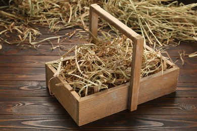 Photo of Dried hay in crate on wooden table