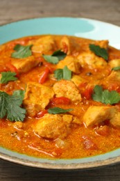 Delicious chicken curry with parsley on table, closeup