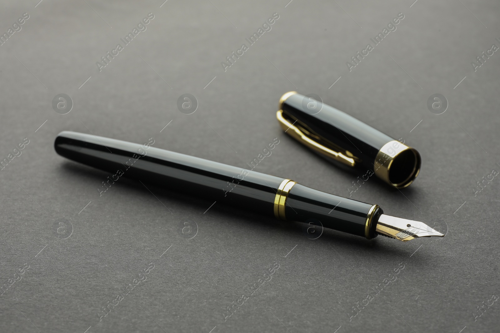 Photo of Stylish fountain pen with cap on grey background