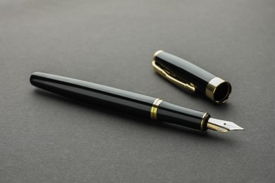 Photo of Stylish fountain pen with cap on grey background