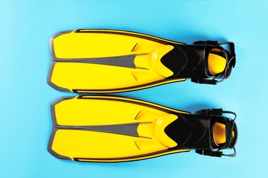 Photo of Pair of yellow flippers on color background, top view