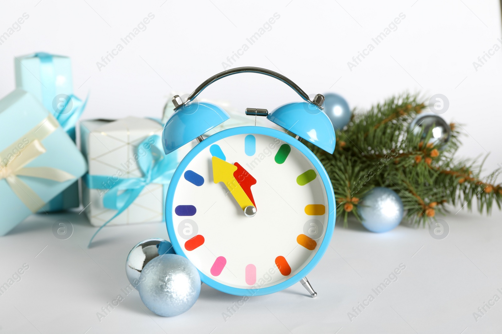 Photo of Alarm clock with Christmas decor on white background. New Year countdown