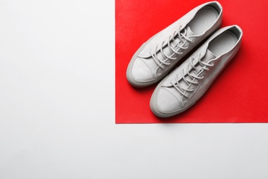 Photo of Stylish sneakers on color background, top view with space for text