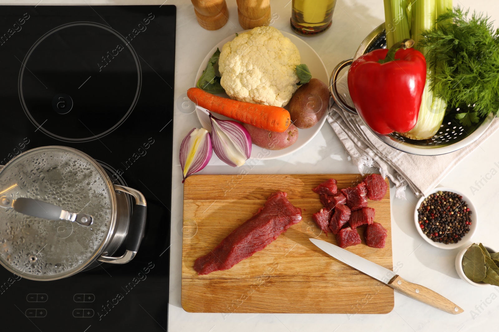 Photo of Homemade bouillon recipe. Fresh ingredients on countertop near stove, flat lay