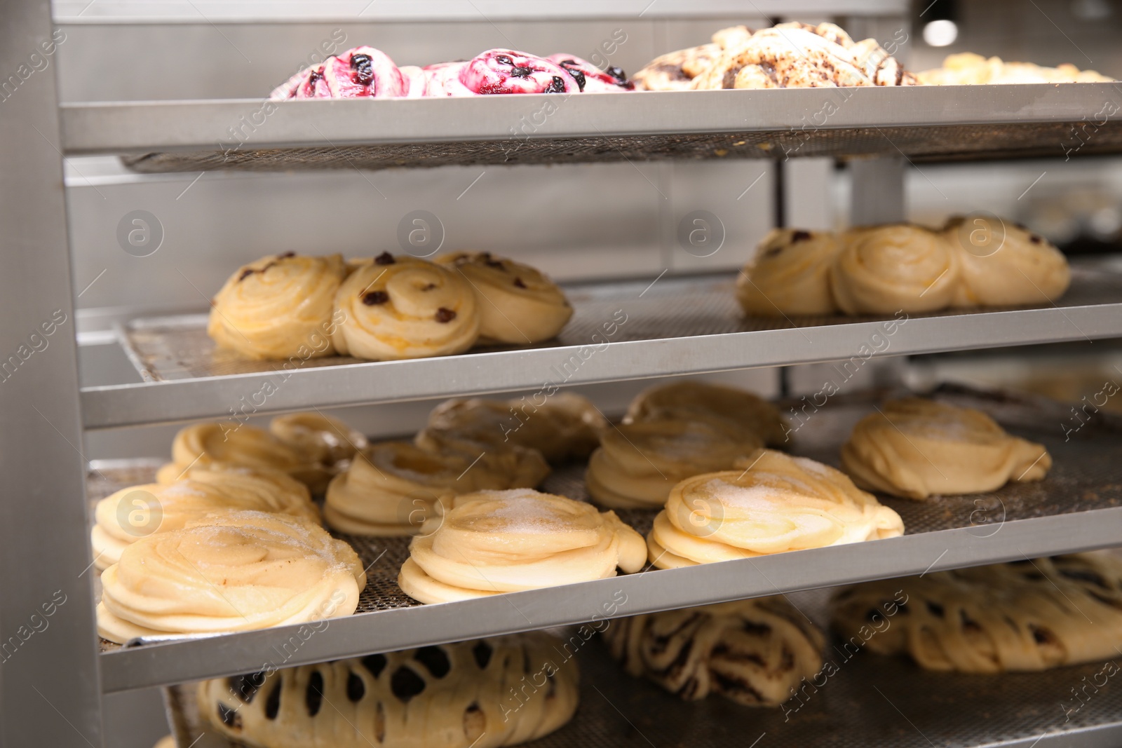 Photo of Rack with different unbaked pastries in workshop