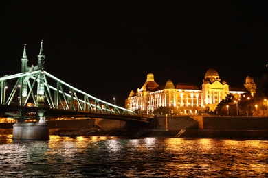Photo of BUDAPEST, HUNGARY - APRIL 27, 2019: Beautiful night cityscape with illuminated Gellert Hotel and Liberty Bridge across Danube river