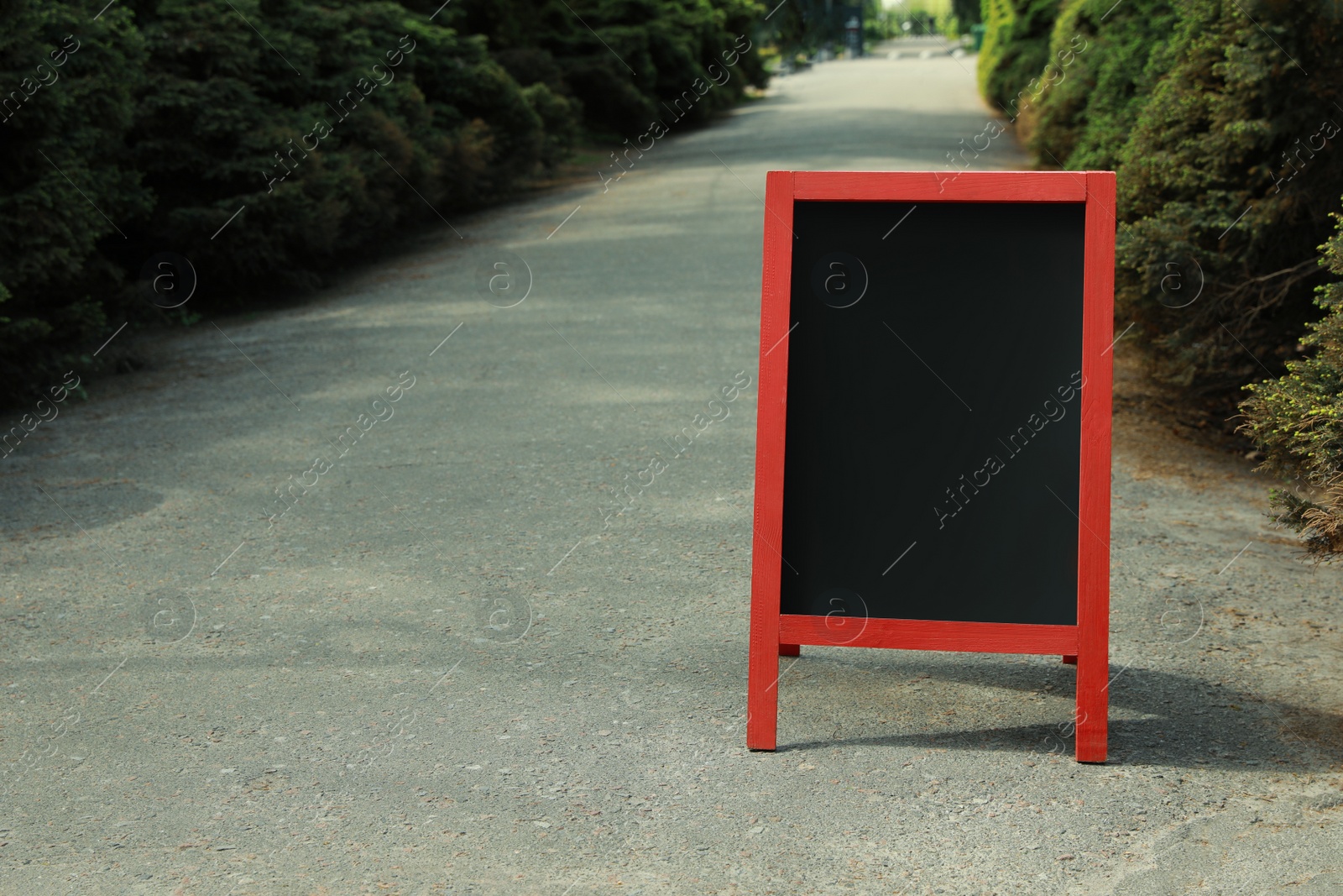 Photo of Blank advertising board on sidewalk in city. Mockup for design