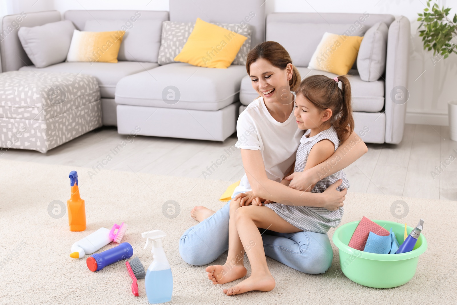 Photo of Housewife and daughter resting after cleaning in room