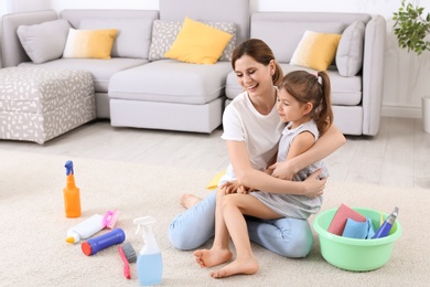 Housewife and daughter resting after cleaning in room