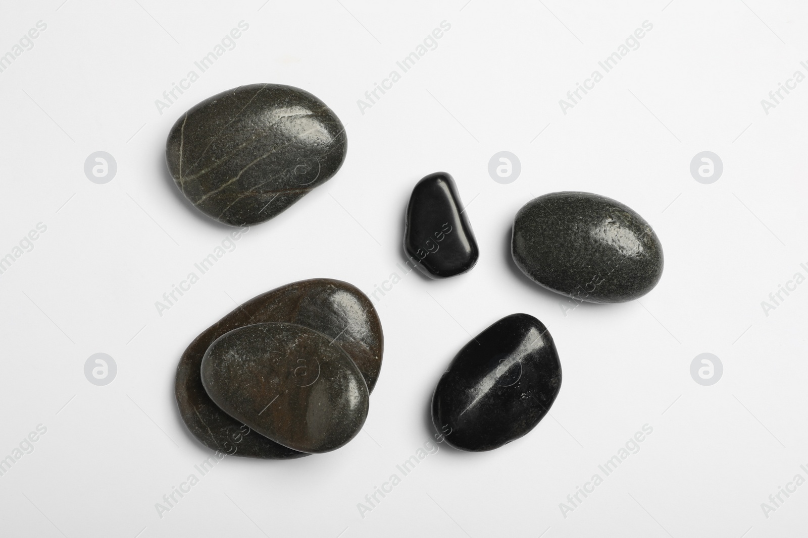 Photo of Many different stones on white background, top view