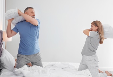 Photo of Mature couple having fun together on bed at home