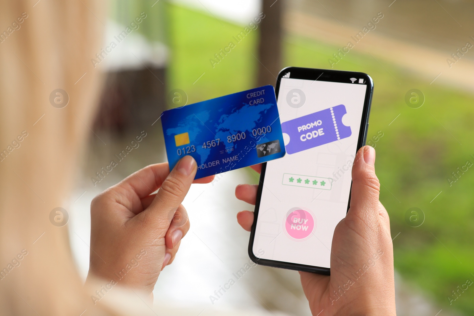 Photo of Woman holding smartphone with promo code and credit card on blurred background, closeup