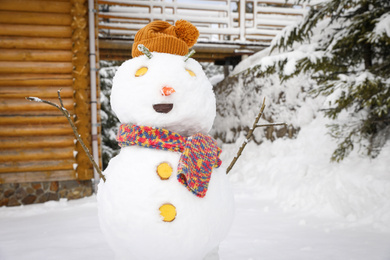 Funny snowman with hat and scarf outdoors. Winter vacation