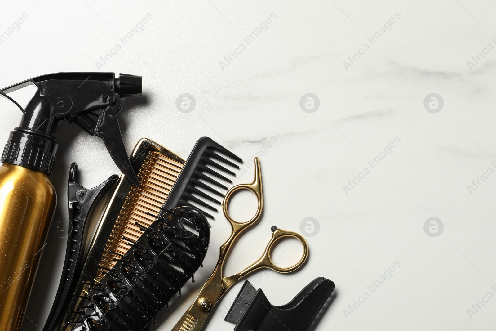 Photo of Hairdressing tools on white marble table, flat lay. Space for text