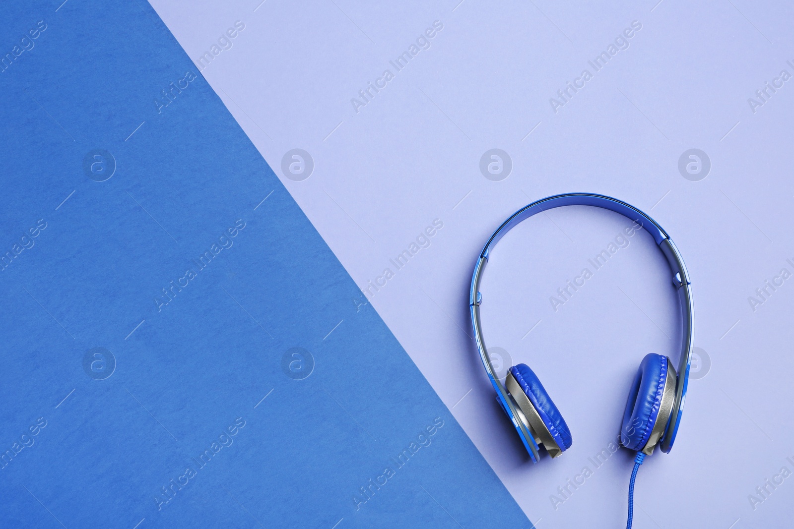 Photo of Stylish headphones on color background, top view. Space for text