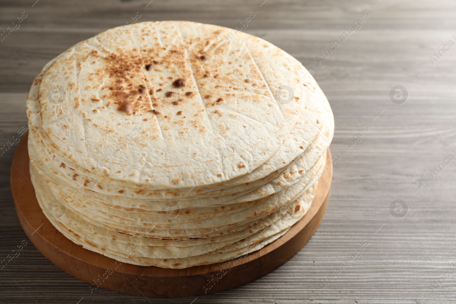 Photo of Many tasty homemade tortillas on wooden table