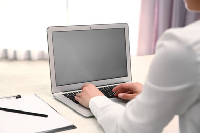 Woman working with modern laptop at white table, closeup. space for design