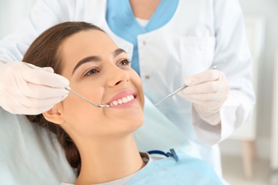 Photo of Dentist examining patient's teeth in modern clinic