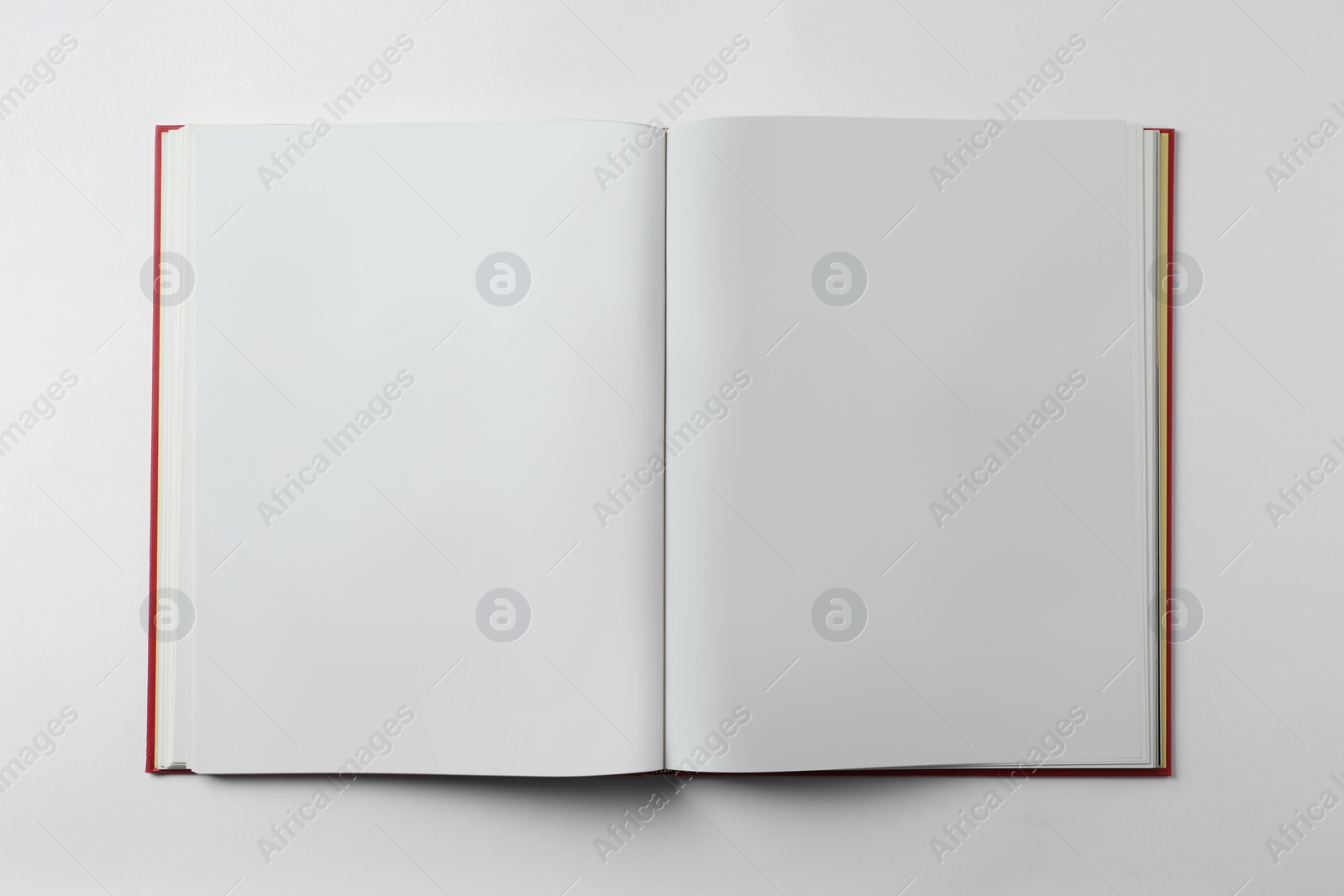 Photo of Open book on white background, top view