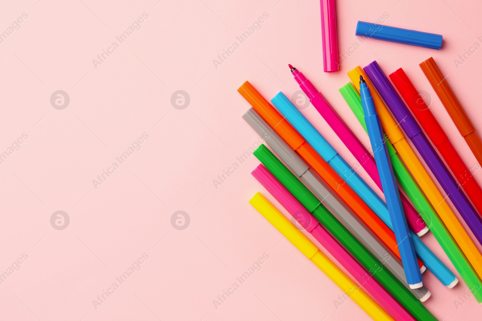 Photo of Many bright markers on pink background, flat lay. Space for text