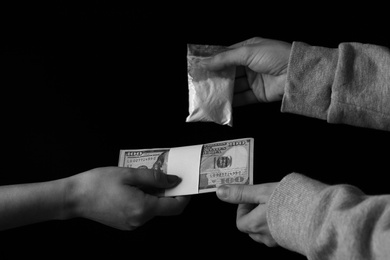 Photo of Drug dealer selling cocaine to addict on black background, closeup