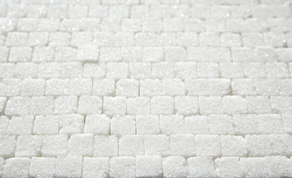 Photo of Refined sugar cubes as background, top view