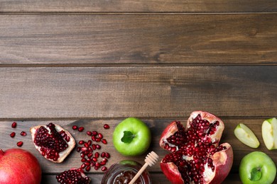 Photo of Honey, pomegranate and apples on wooden table, flat lay with space for text. Rosh Hashana holiday