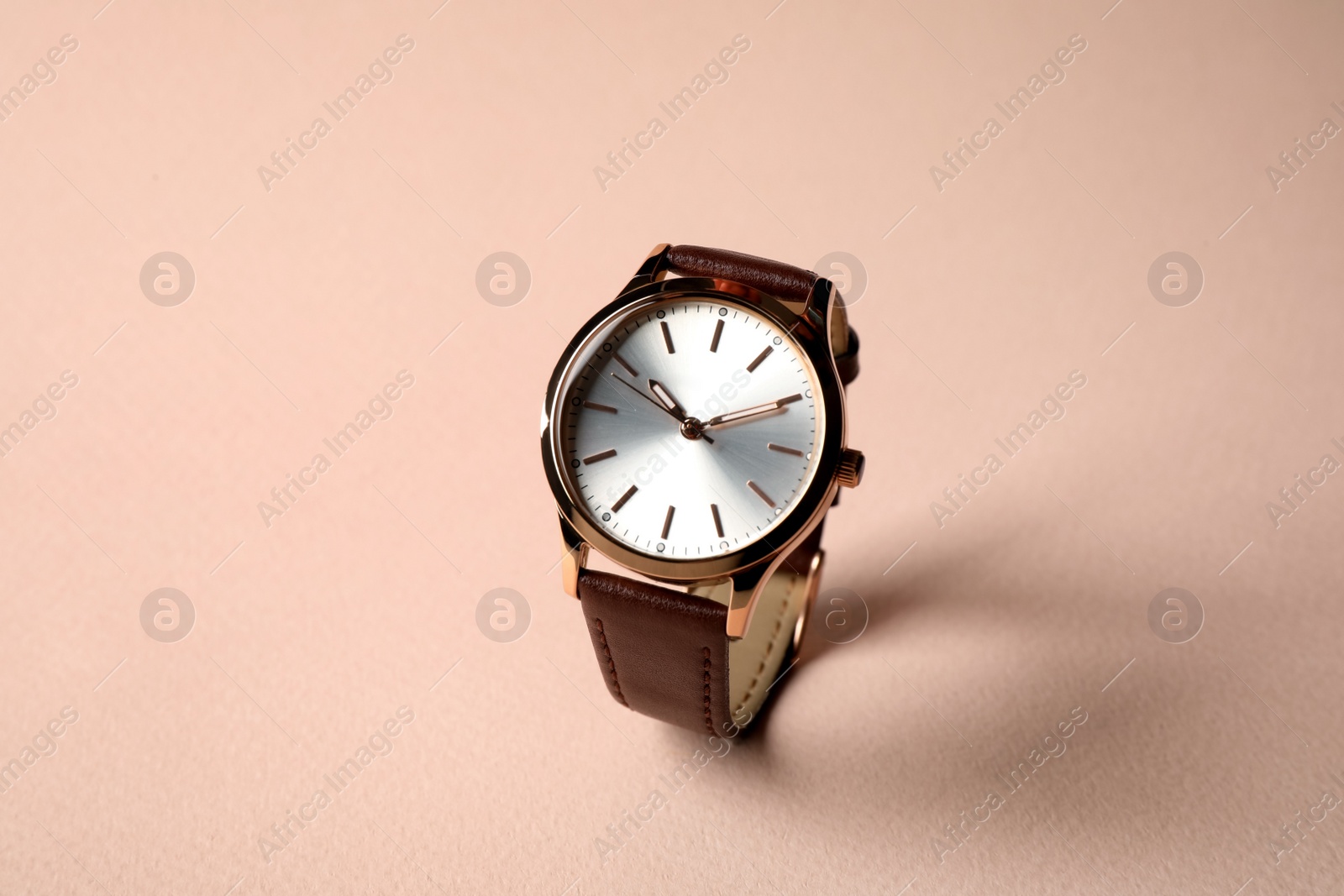 Photo of Luxury wrist watch on pale pink background. Fashion accessory