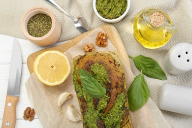 Freshly baked pesto bread with ingredients on table, flat lay