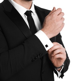 Man wearing stylish suit and cufflinks on white background, closeup