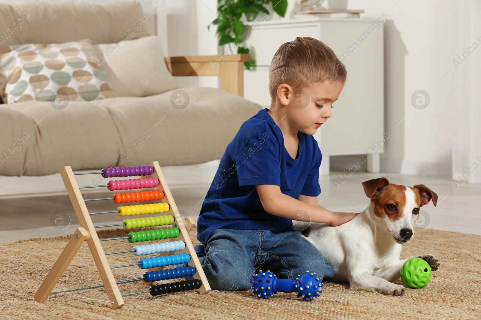 Photo of Little boy playing with his cute dog at home. Adorable pet