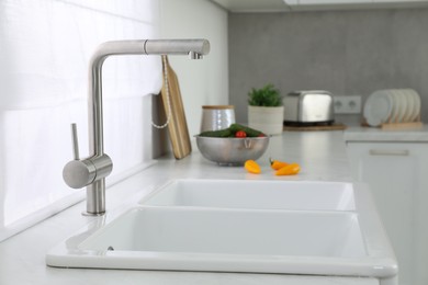 Modern sink and water tap on kitchen counter. Interior design