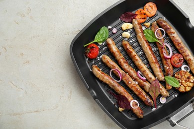 Grill pan with tasty sausages and vegetables on light table, top view. Space for text