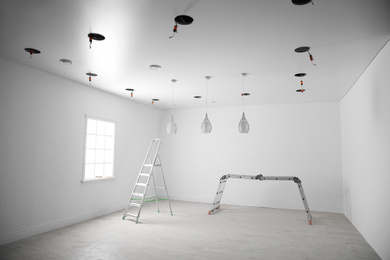 Empty room with stretch ceiling and ladders