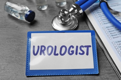 Badge with inscription UROLOGIST on table, closeup