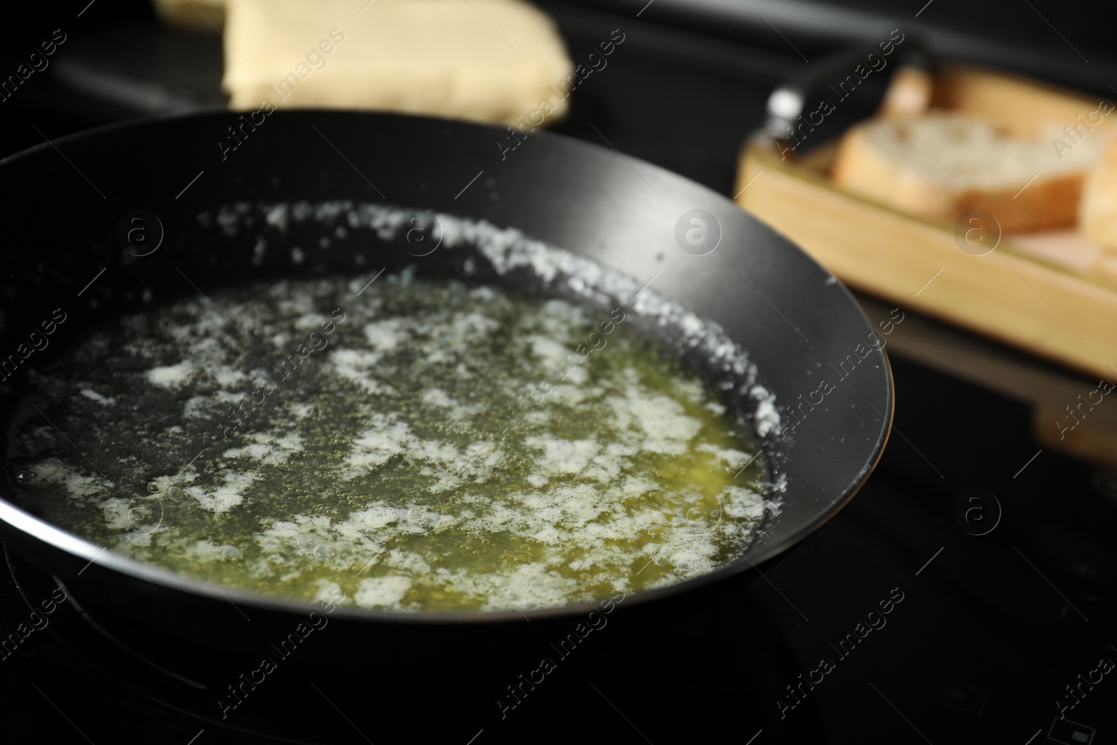 Photo of Melting butter in frying pan on black table, closeup