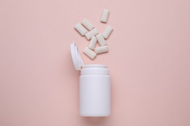 Photo of Jar with chewing gums on light pink background, flat lay