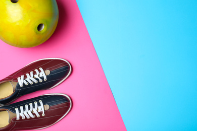 Photo of Bowling ball and shoes on color background, flat lay. Space for text