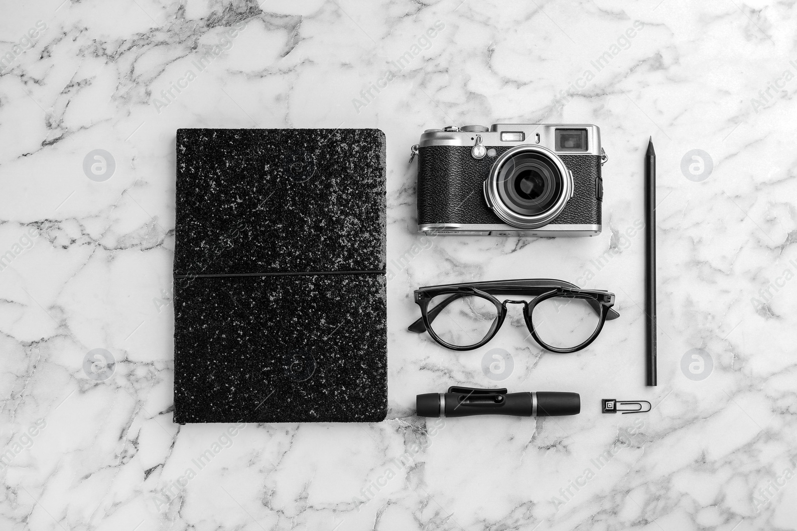 Photo of Flat lay composition with camera for professional photographer and accessories on white marble table