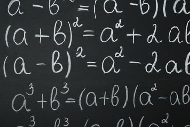 Photo of Many different math formulas written on chalkboard, closeup