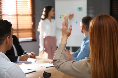 Photo of Woman raising hand to ask question at seminar in office, closeup