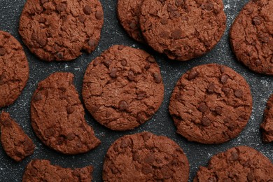 Tasty chocolate cookies on grey textured table, flat lay