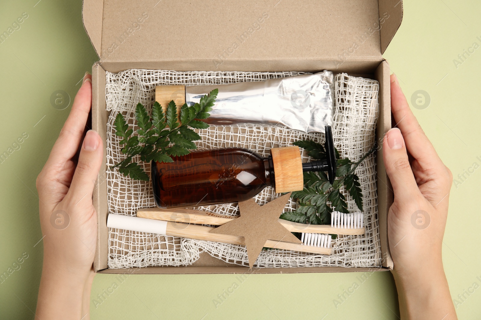 Photo of Woman with eco friendly personal care products on light green background, top view