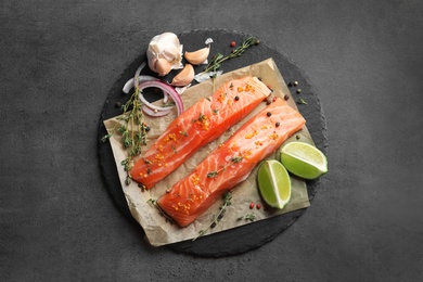 Photo of Fresh salmon and ingredients for marinade on slate plate