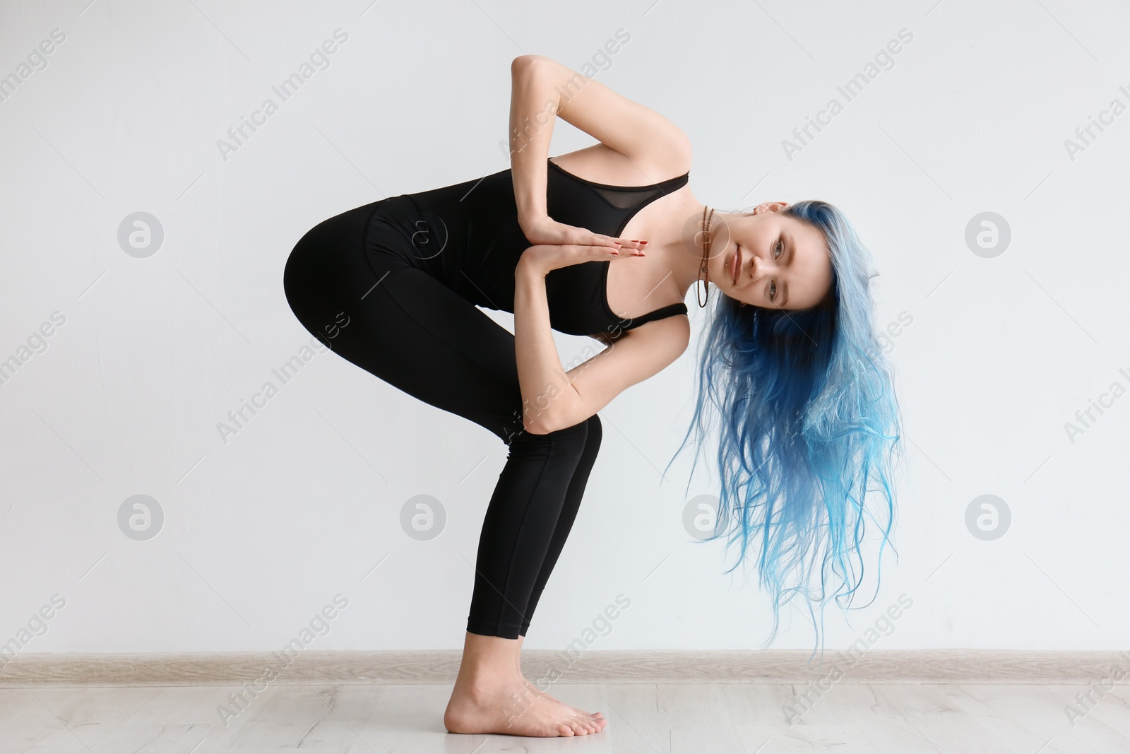 Photo of Young woman practicing yoga indoors